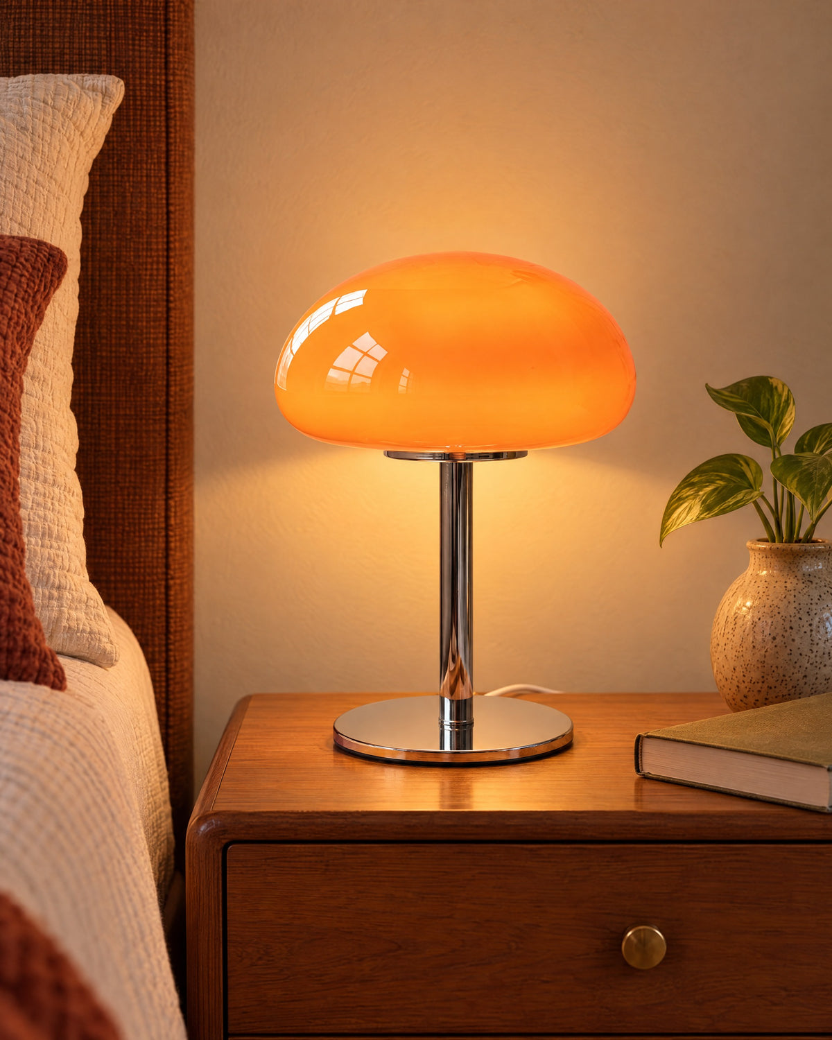 Orange: Retro Glass Mushroom Nightstand Lamp switched on on a nightstand in the evening