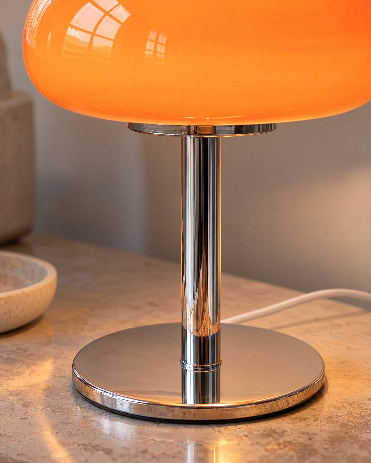Orange: Close-up of the glass dome and polished chrome stem of the Retro Glass Mushroom Nightstand Lamp