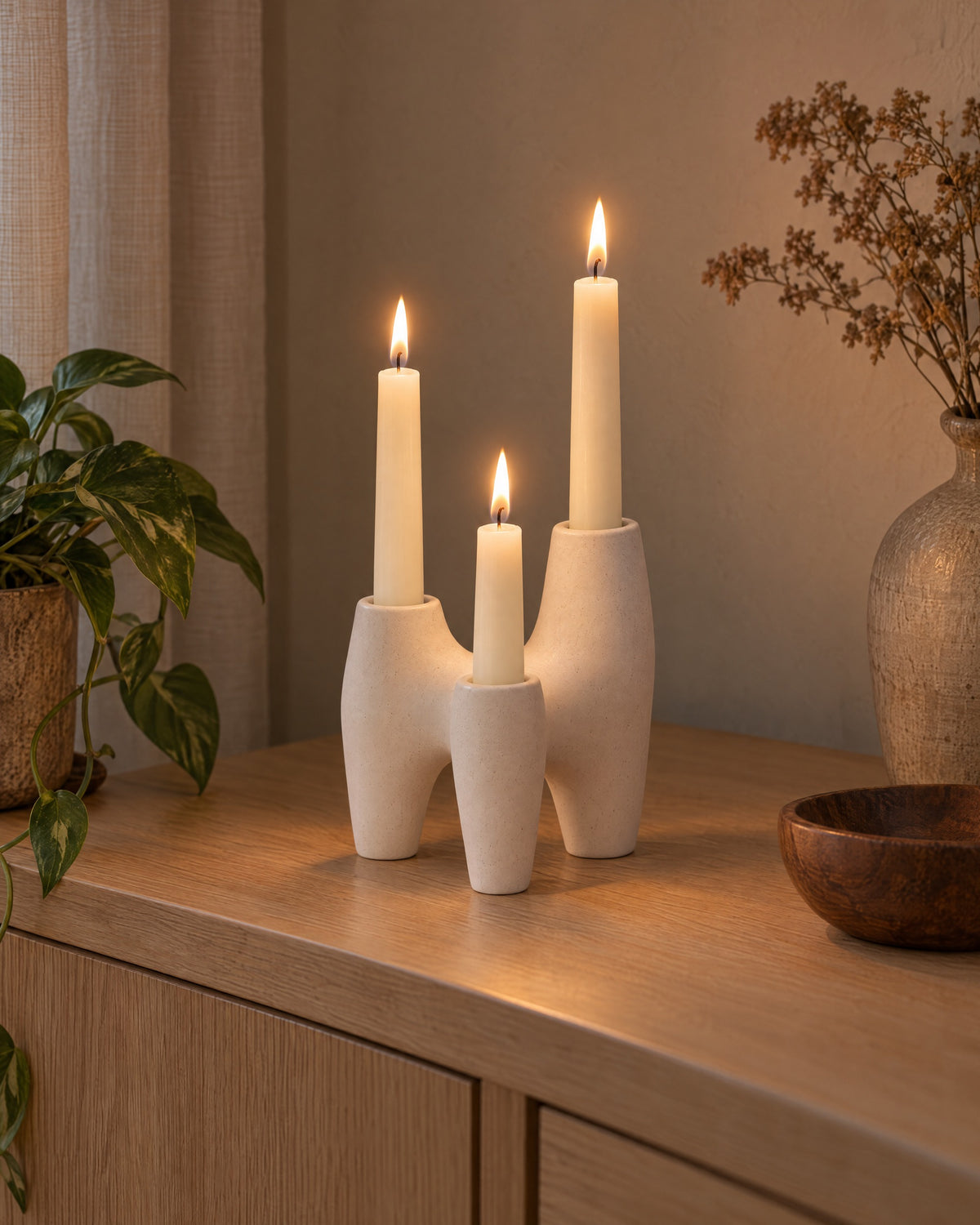 Duna Sculptural Ceramic Candle Holder styled in a warm interior at dusk