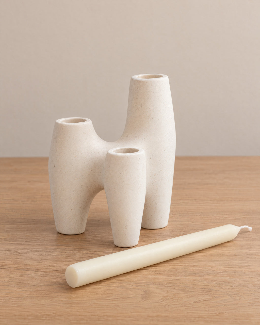 Duna Sculptural Ceramic Candle Holder with the candle type that fits, shown beside it