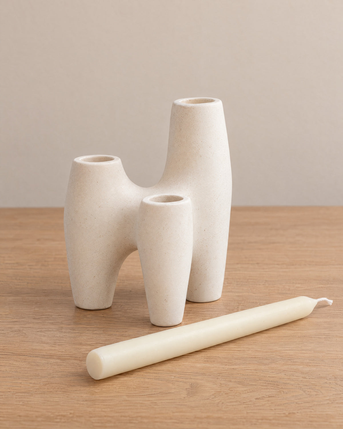 Duna Sculptural Ceramic Candle Holder with the candle type that fits, shown beside it