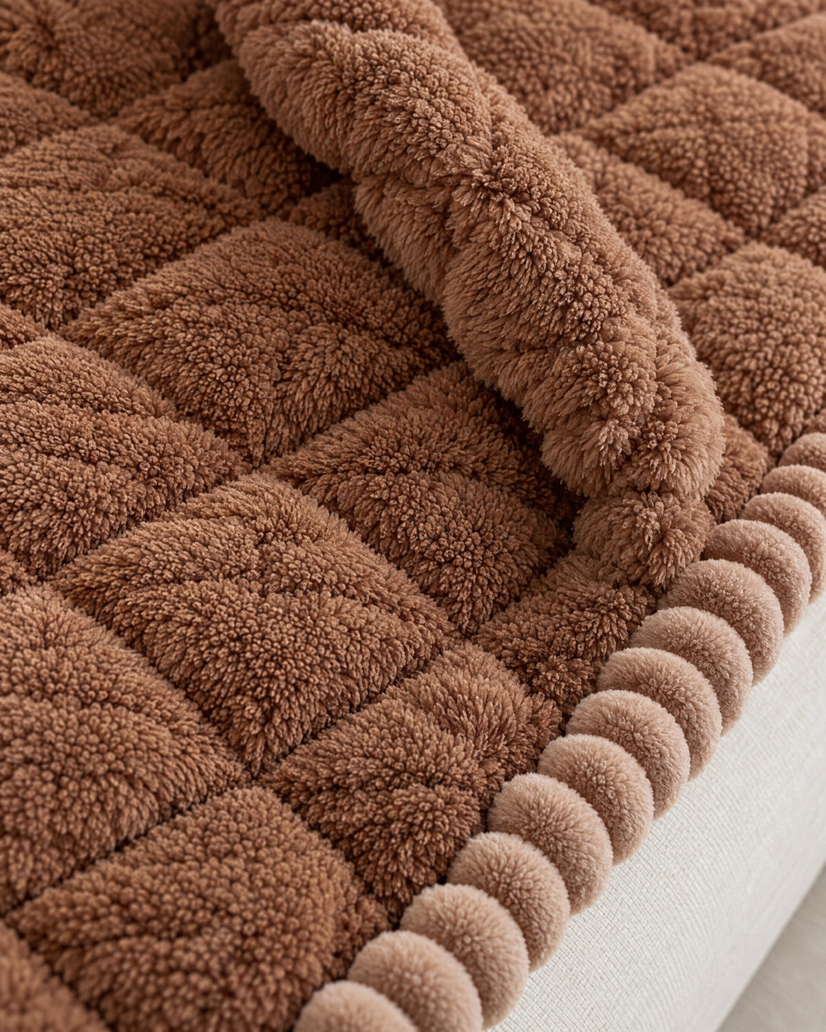 Mocha Brown: Close-up of the edge finish of the Snuggle Sherpa Plush Sofa Protector Cover