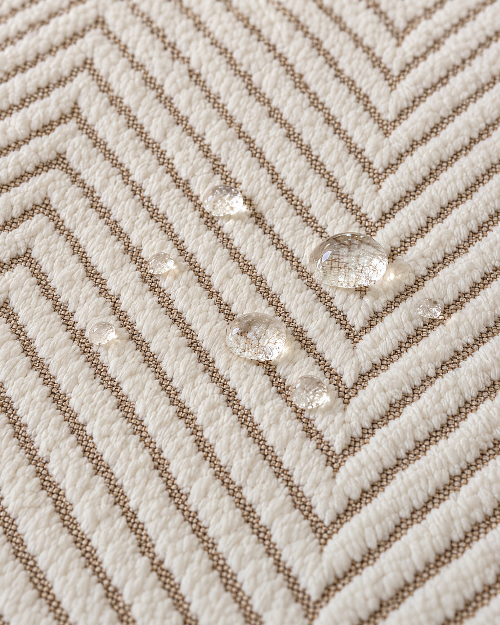 Ivory Sand: Water droplets beading on the fabric of the Stripe Herringbone Sofa Cover