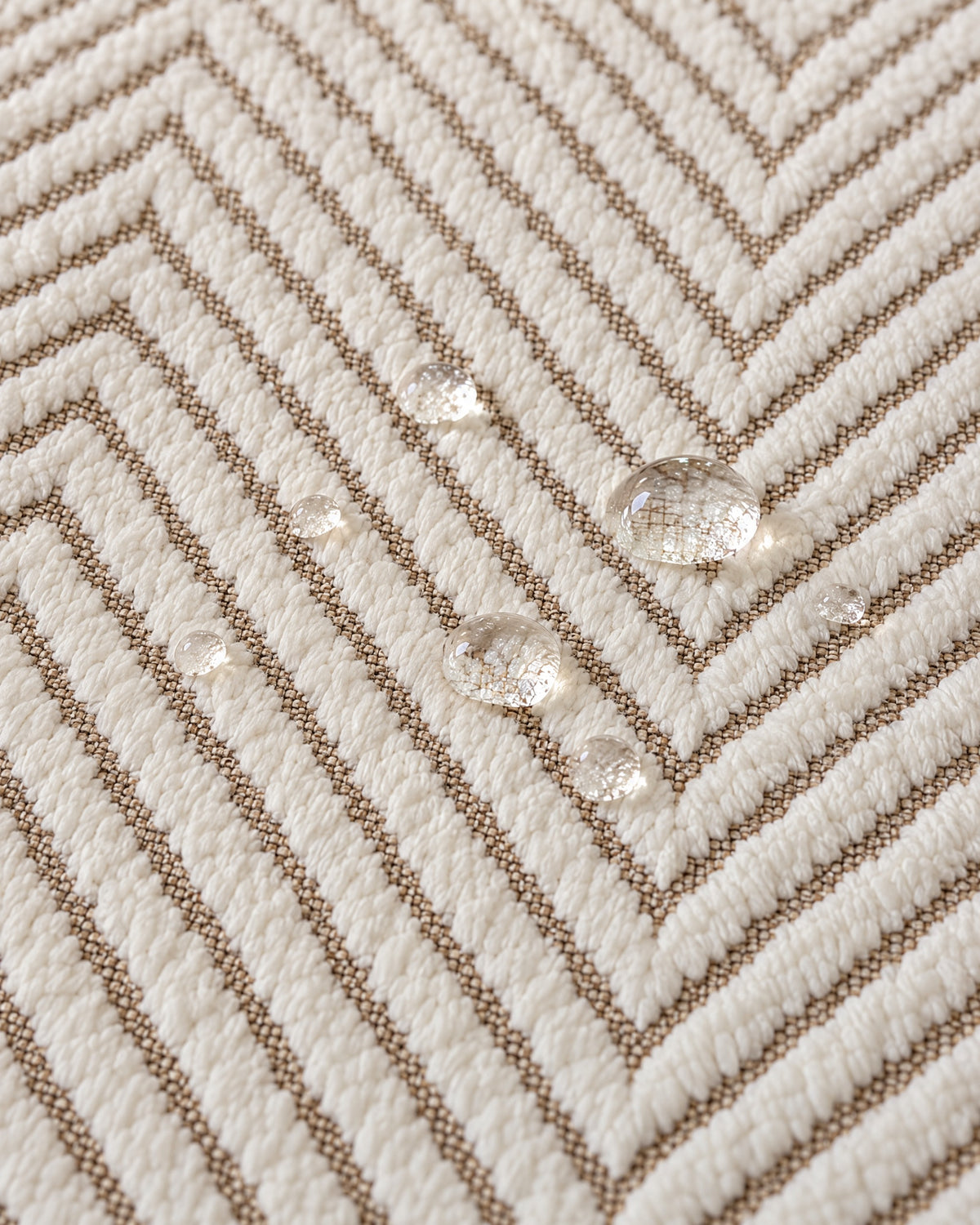 Ivory Sand: Water droplets beading on the fabric of the Stripe Herringbone Sofa Cover