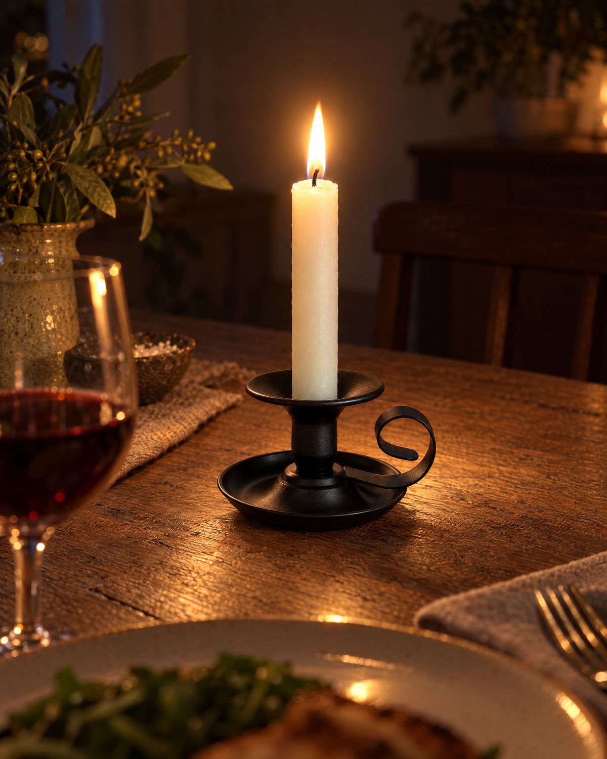 Tazza Iron Teacup Candle Holder with candles lit at night on a dinner table