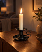 Tazza Iron Teacup Candle Holder with candles lit in the evening on a sideboard in a dim living room