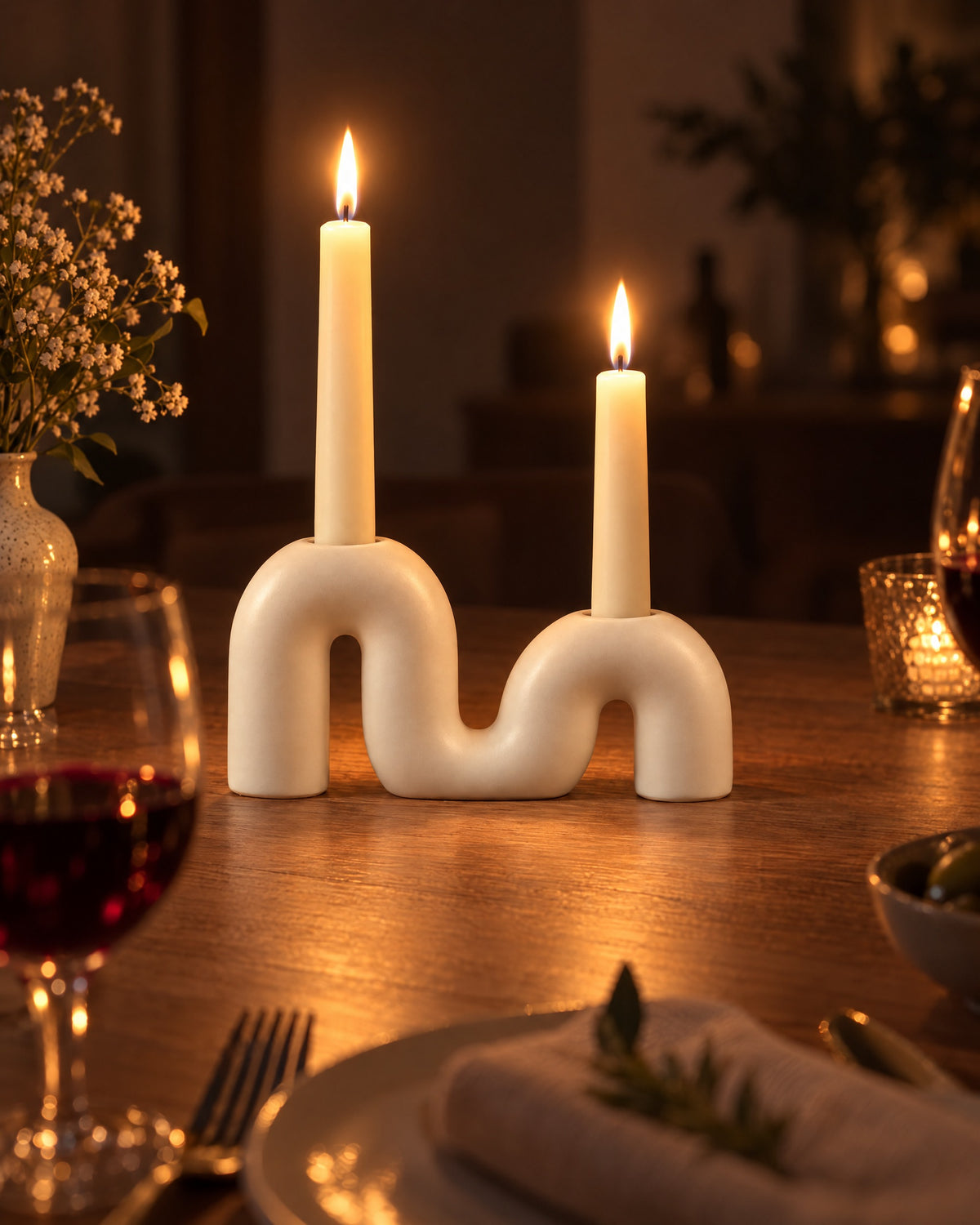 Twist Ceramic Double Candle Holder with candles lit at night on a dinner table