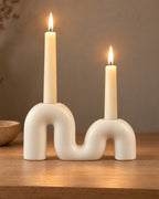 Twist Ceramic Double Candle Holder, lit, on a styled surface in the evening