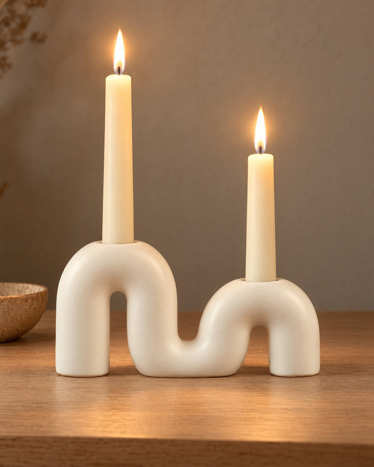 Twist Ceramic Double Candle Holder, lit, on a styled surface in the evening