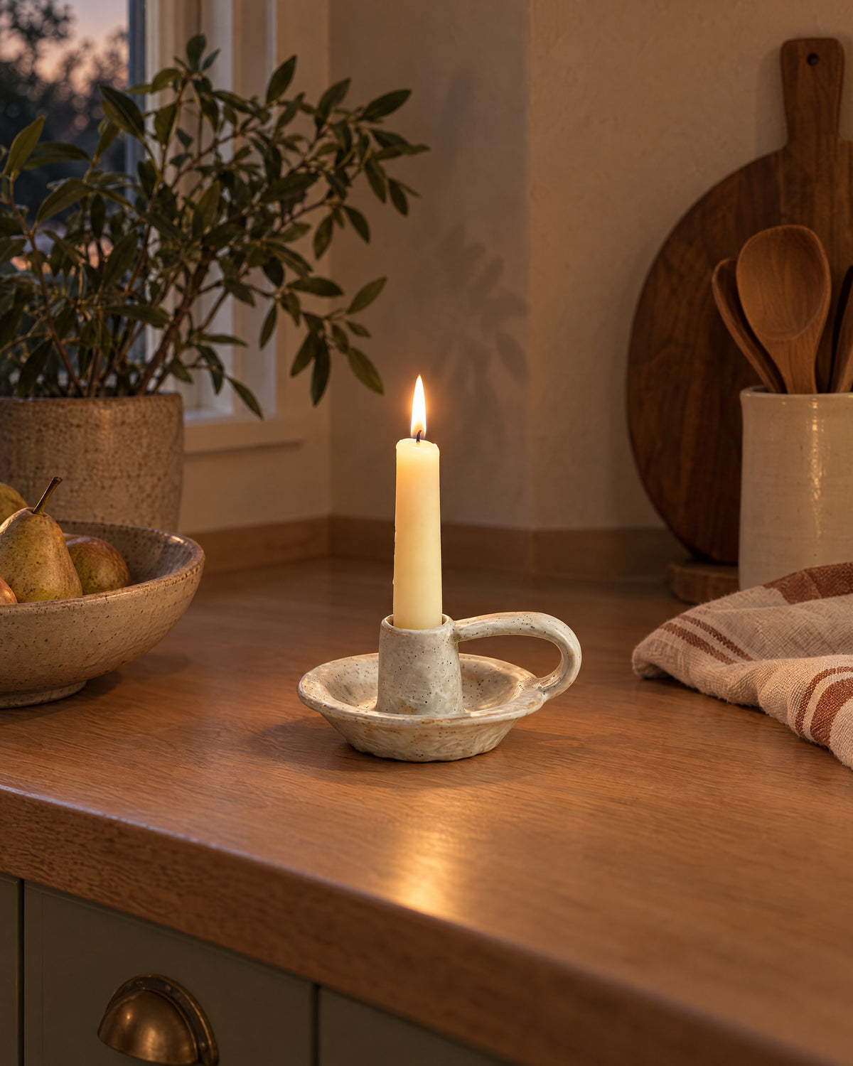 Wabi Speckled Ceramic Chamberstick styled in a warm interior at dusk