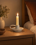 Wabi Speckled Ceramic Chamberstick, lit, in a lived-in evening scene