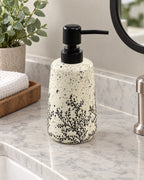 White Soap Dispenser, Speckled Ceramic, Black Pump, 11 oz on a bathroom vanity in soft daylight