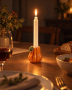 Zucca Pumpkin Ceramic Candle Holder with candles lit at night on a dinner table
